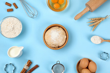 Flat lay composition with raw eggs and other ingredients on light blue background. Baking pie