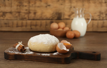 Raw eggs, dough and cinnamon on wooden table. Baking pie