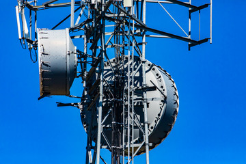 A closeup and detailed view of a cellular network base station with microwave antenna fixed to...