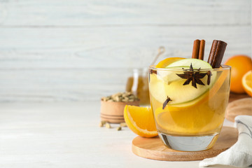 Aromatic white mulled wine on wooden table. Space for text