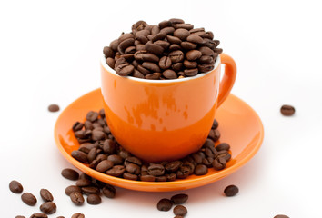 Roasted coffee beans in an orange cup