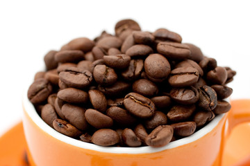 Roasted coffee beans in an orange cup