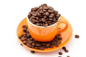 Roasted coffee beans in an orange cup