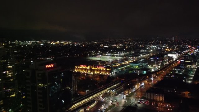Aerial view of night city with the highway and railway station in the night