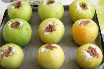 green apples stuffed with sugar and cinnamon on a baking tray, a way of baking apples in the oven, the cooking process