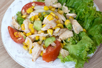 Salad with chicken breast, green peas, corn seeds dressed with low-calorie yogurt. Home salad with meat and vegetables. Top view, menu for a diet