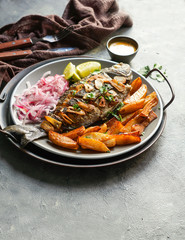 Chita frita al ajo, al ajillo, Peruvian food,  a whole fish, served wit rice, batata, onion salad and rice.
