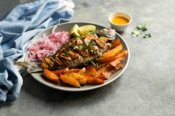 Chita frita al ajo, al ajillo, Peruvian food,  a whole fish, served wit rice, batata, onion salad and rice.
