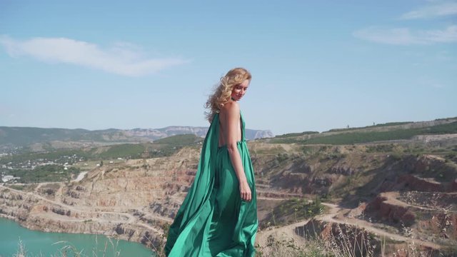 Young adult girl standing outdoors in graceful green dress