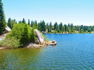 Beautiful lake landscape with green trees and blue water.