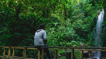 Man enjoying and relaxing in the forest sitting in the wood