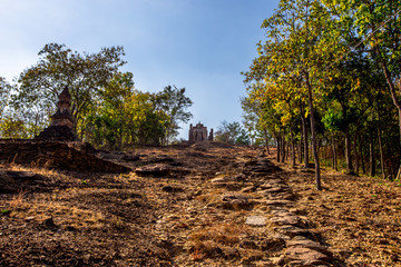 The blurry nature background of the Wat Saphan Hin walkway has long, stone bridges on a hill, with...