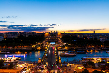 Panoramic view of Paris at night seen from the first floor of the Eiffel Tower. Long-exposure shot during sunset showing Pont d'Iéna (Jena Bridge), a bridge spanning the River Seine.