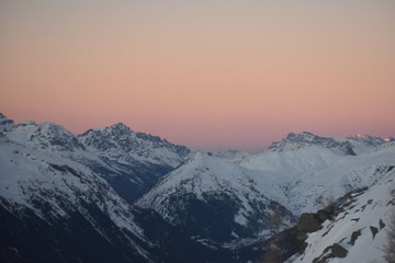 Fototapeta na wymiar Snowy mountains in hazy sunset