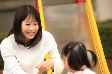 すべり台で遊ぶ親子