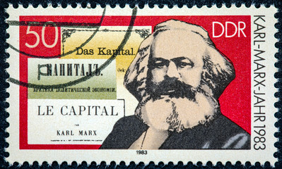 A stamp printed in German Democratic Republic shows Karl Marx and the book 