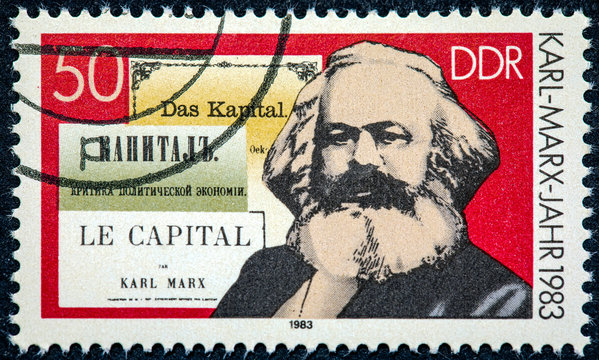 A stamp printed in German Democratic Republic shows Karl Marx and the book "Capital"