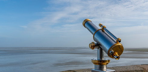 spyglass in first line of sea, of silver and gold chlorine next to a wall
