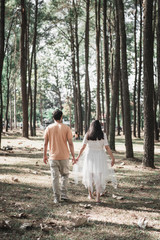 Fototapeta premium Pregnant woman and Husband posing outdoors.