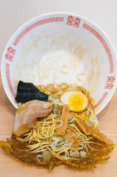 Japanese Spilled Ramen. Bowl of noodles, egg, and pork spilling out of a bowl onto the table. Example of plastic food model famous in Japan. 