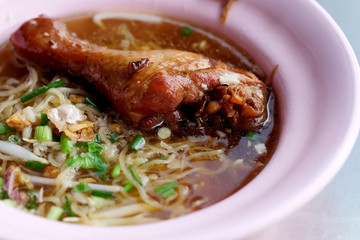 Braised Chicken Leg Noodle in plastic bowl and space for write wording, popular street food sold in market and restaurant, danger from dirty, dust and unhealthy material.