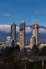  New construction of high-rise buildings in the city of Burnaby construction site in the center of the city against the backdrop of a mountain ridge