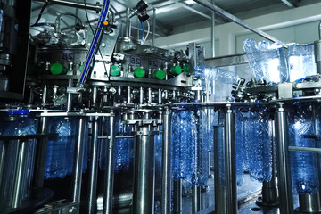 Filling line of sparkling water in pet bottle. Mini factory for