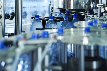 Filling line of sparkling water in pet bottle. Mini factory for bottling water.