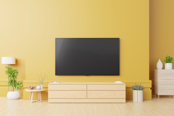 Smart Tv Mockup in modern living room with lamp,table,flower and plant on yellow wall background.