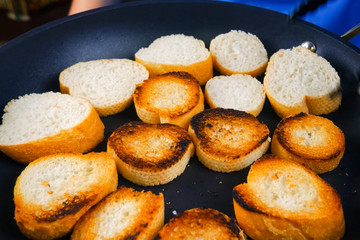 Frying slices of bread in a pan. Toasting bread for sandwich.