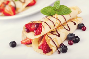 Delicious pancakes with berries on a white plate