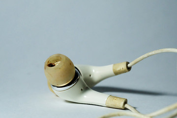 Old dirty plug in earphone on white background and space for write wording, high risk of ear and respiratory tract infection disease cause illness and financial problem