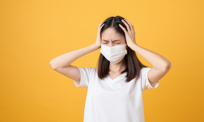 Asian women wear masks to protect disease and the headache from a virus on orange background.