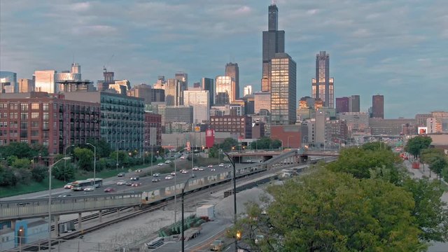 Aerial: The Chicago city skyline & traffic on the 290 Freeway at sunset. Illinois, USA.
