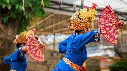 Foto op Canvas Aziatische reizen achtergrond. Groep mooie Balinese danseressen in traditionele sarong-kostuums met fans in handen die Legong-dans dansen. Kunst, cultuur van Indonesische mensen, festivals op Bali. © Tropical studio