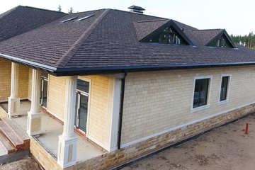 Bituminous tile for a roof. House with a roof from a bituminous