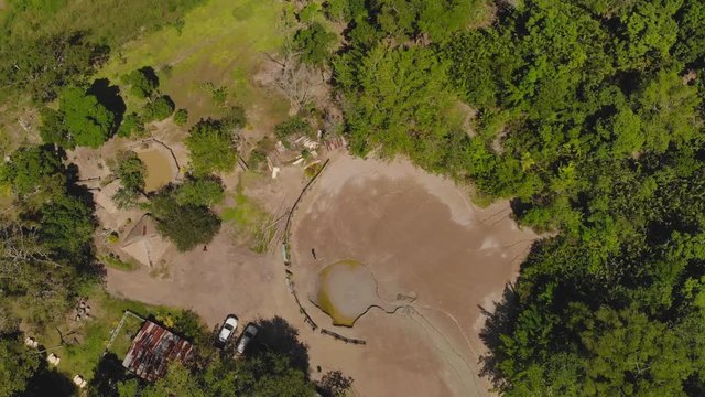 Ascending aerial of a mud volcano only accessible by four wheel drive vehicle in the dense rain forest of Penal, Trinidad and Tobago