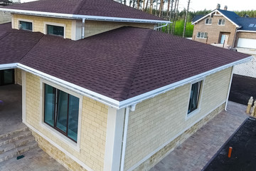 Bituminous tile for a roof. House with a roof from a bituminous