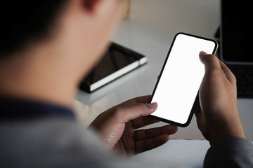 Cropped shot view of man hands holding smart phone with blank copy space screen for your text message or information content, female reading text message on cell telephone during in urban setting. 