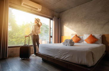 Fototapeta Tourist woman with her luggage in hotel bedroom. obraz