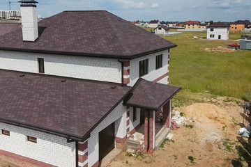 Bituminous tile for a roof. House with a roof from a bituminous