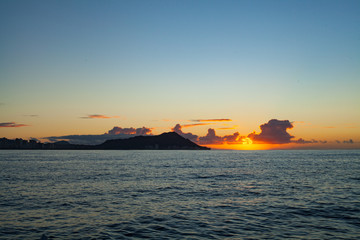 Fototapeta premium Beautiful Orange Sunrise over the Ocean from a Boat - Waikiki Sunrise over Diamondhead