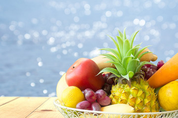 fruit on wooden table and swimming pool background