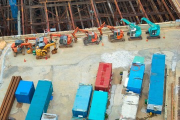 Fototapeta na wymiar Excavators, bulldozers and containers at a construction site. Very high angle view.