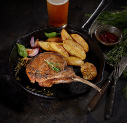 grilled pork steak tomahawk in a pan on a dark background