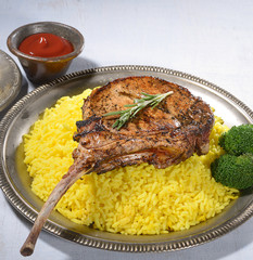 Tomahawk pork steak with rice on a gray background