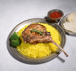 Tomahawk pork steak with rice on a gray background