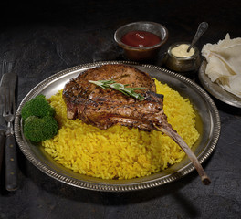 grilled  Tomahawk pork steak with rice on a dark background