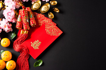 Fototapeta na wymiar Chinese new year festival decorations pow or red packet, orange and gold ingots or golden lump on a black background. Chinese characters FU means fortune good luck, wealth, money flow.