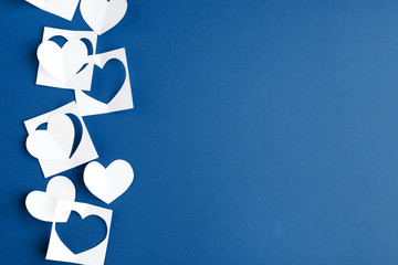 Paper hearts on classic blue background. Empty place for copy space for text. mock-up, minimal concept of romance winter february holiday. saint Valentine day